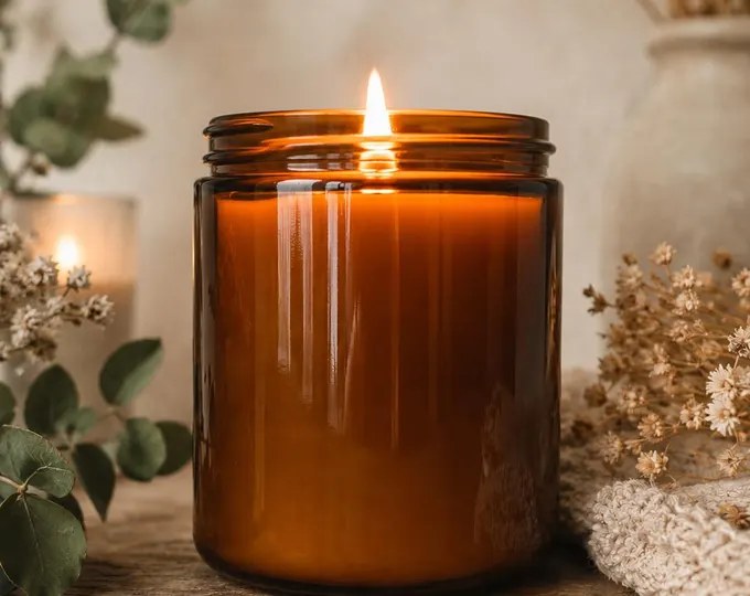 A lit candle in a glass jar